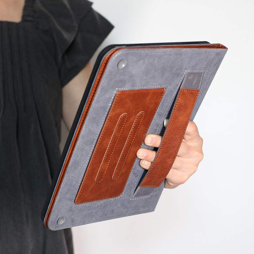 Person holding a gray and brown leather-bound book or notebook.